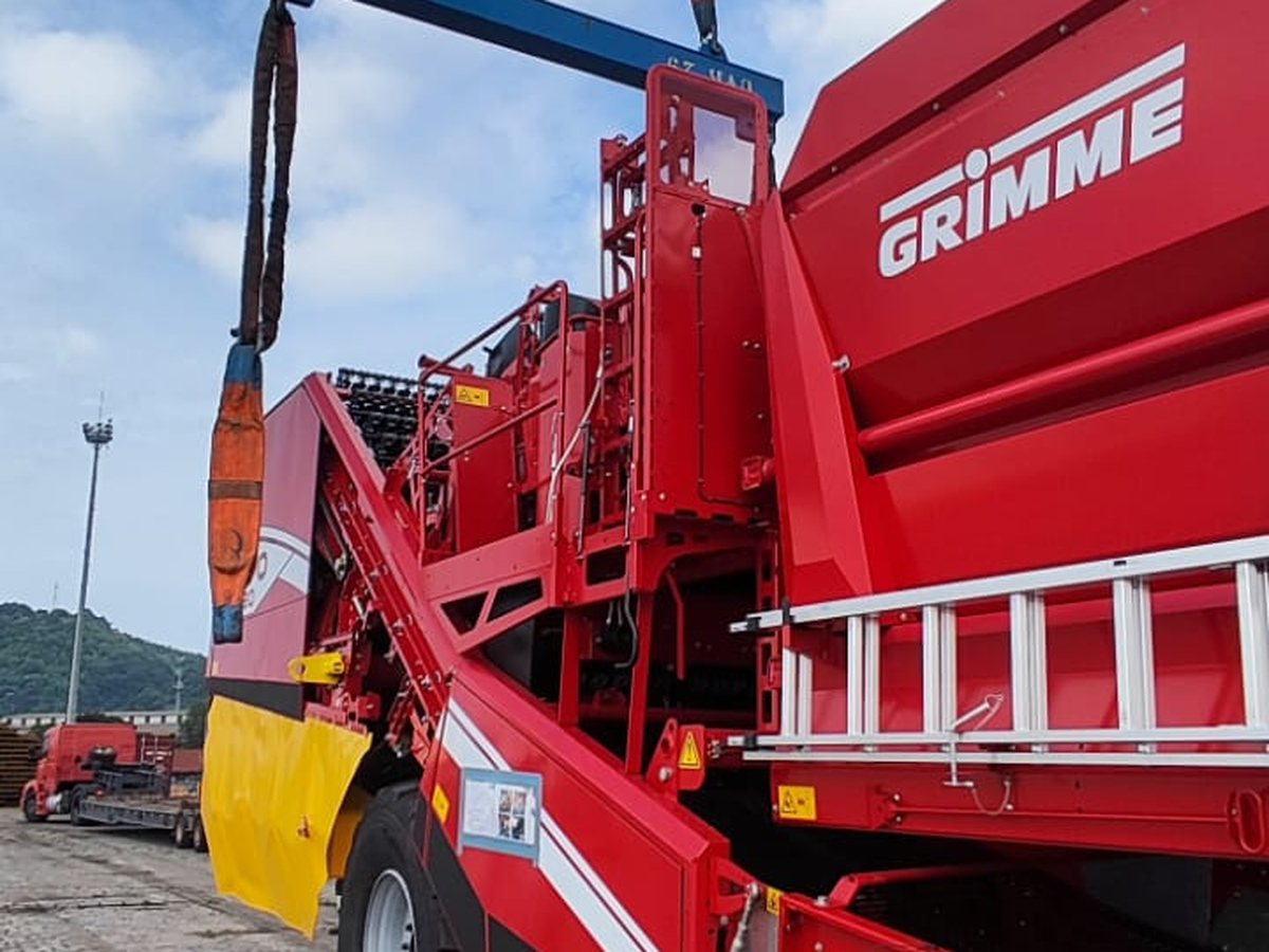 Colhedora Grimme içada por reach stacker no recinto alfandegado